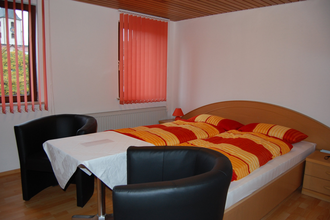 Doppelzimmer mit Bett und zwei Sesseln | © Hohenlohe Künzelsau | Gasthaus Ochsen