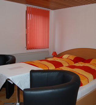 Doppelzimmer mit Bett und zwei Sesseln | © Hohenlohe Künzelsau | Gasthaus Ochsen