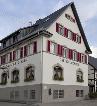 Der Gasthof von außen hat rote Fensterläden und ist weiß und unten grau gestrichen | © Touristikgemeinschaft Hohenlohe e. V. | Gasthof Ochsen