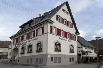 Der Gasthof von außen hat rote Fensterläden und ist weiß und unten grau gestrichen | © Touristikgemeinschaft Hohenlohe e. V. | Gasthof Ochsen
