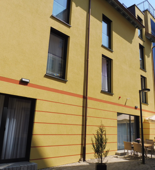 Der Gasthof von außen hat eine gelbe Fassade | © Touristikgemeinschaft Hohenlohe e. V. | Gasthof Engel