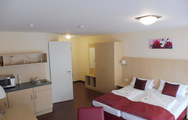 Im Appartement steht ein Doppelzbett und eine Küchenzeile | © Touristikgemeinschaft Hohenlohe e. V. | Gasthof Engel
