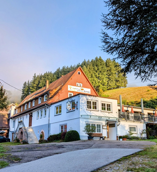 Eine malerische Scheune im Vordergrund, während ein gemütlicher Weg vorbeiführt und direkt zum einladenden Gasthof leitet. | © Gasthof Goldene Krone