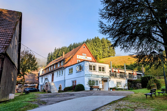 Eine malerische Scheune im Vordergrund, während ein gemütlicher Weg vorbeiführt und direkt zum einladenden Gasthof leitet. | © Gasthof Goldene Krone