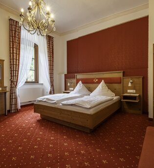 Gemütliches Doppelbett mit Fernseher und Kofferablage | © Touristikgemeinschaft Hohenlohe e. V. | Dominik Rau