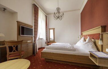 Komfortables Doppelbett mit Schreibtisch und Fernseher | © Touristikgemeinschaft Hohenlohe e. V. | Dominik Rau