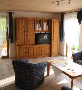 Wohnzimmer mit Couch, Tisch und Schrank | © Touristikgemeinschaft Hohenlohe e. V.  | Haus am Limes