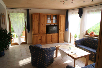 Wohnzimmer mit Couch, Tisch und Schrank | © Touristikgemeinschaft Hohenlohe e. V.  | Haus am Limes