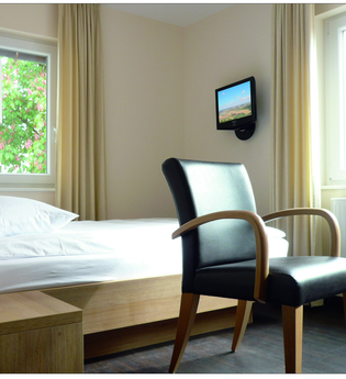 Ein Komfortzimmer mit Bett, TV, Schreibtisch und Stuhl | © Touristikgemeinschaft Hohenlohe e. V. | Hotel-Cafe Mainzer Tor