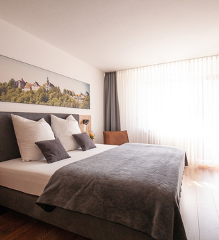 Komfortdoppelzimmer mit Doppelbett und Schreibtisch | © Touristikgemeinschaft Hohenlohe e. V. | Ingrid Düstersiek-Schuster