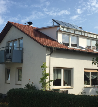 Ein weißes Haus mit Balkon und Garten. | © Ilse Hofmann