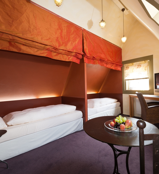 Blick in die Minisuite "Cuvée-Weinspitz" im Hotel Laurentius. Es ist ein Zweibettzimmer im Dachgeschoss. Die beiden Betten können jeweils getrennt voneinander mit einem Stoffrollo abgedunkelt werden. | © Unbekannt