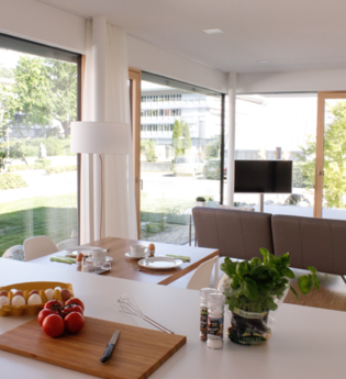 Von der Küchenzeile hat man einen schönen Blick über den Wohnbereich ins Grüne | © Touristikgemeinschaft Hohenlohe e. V. |  Werbeagentur Neckarmedia