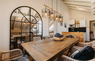 Ein Tisch mit Stühle, an der Wand ein großer Spiegel. Auf dem Tisch sind frische Weintrauben | © Tim Hasl