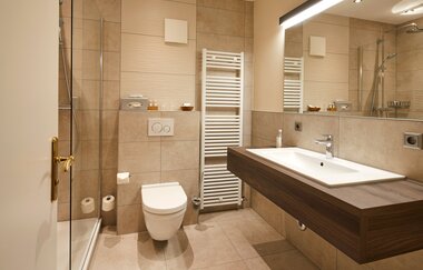Badezimmer mit Dusche, Toilette und Waschbecken im Hotel Stumpf | © NaturKulturHotel Stumpf