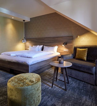 Doppelzimmer mit Sessel und Tisch im Hotel Stumpf | © NaturKulturHotel Stumpf