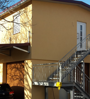 Das Haus von außen ist sandfarben und hat eine Treppe in den ersten Stock | © Touristikgemeinschaft Hohenlohe e. V.