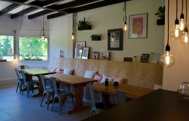 Gastraum mit drei Tischen und Sitzgelegenheiten. An der Wand hängen Bilder. Odenwald. | © ODENWALD river camp