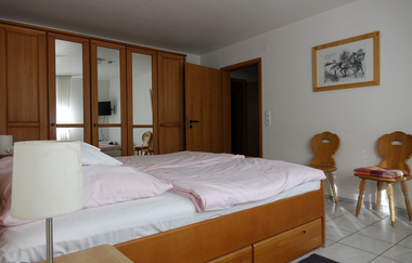 Aufnahme des Doppelzimmers. Neben dem Doppelbett gibt es einen hölzernen Spiegelschrank, zwei Holzstühle und ein Nachtschränkchen mit Lampe. | © Neckar-Zaber-Tourismus e.V.