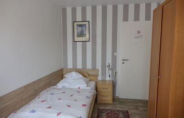 Einzelzimmer mit einem Bett, Nachtschränkchen und einem großen hölzernen Schrank | © Neckar-Zaber-Tourismus e.V.