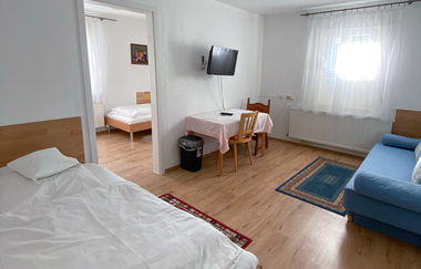 Aufnahme des Appartements: Großer Raum mit Couch, Tisch mit zwei Stühlen und einem Durchgang ins Nebenzimmer indem auch noch ein Bett steht | © Neckar-Zaber-Tourismus e.V.