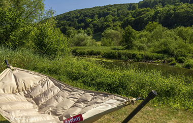 Entspannen in der Hängematte an der Jagst im Ferienhaus Renkenmühle bei Mulfingen | © Touristikgemeinschaft Hohenlohe e. V. | Uwe Stöffler, Fotografie, Blaufelden