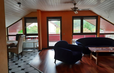 Wohnzimmer mit Couch und Sessel und Blick ins Grüne | © Touristikgemeinschaft Hohenlohe e. V.