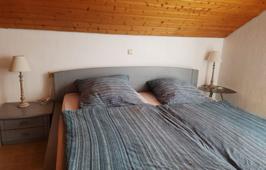 Doppelbett mit grauer Bettwäsche bezogen | © Touristikgemeinschaft Hohenlohe e. V.