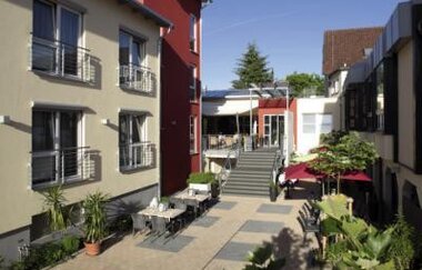 Innenhof mit Außenterrasse und Tischen des Hotel Bundschu, umgeben von mehrstöckigen Gebäuden mit Balkonen | © Ringhotel Bundschu