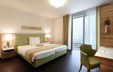 Helles modernes Hotelzimmer im Schloß-Hotel Ingelfingen mit Bett und Schreibtisch | © Touristikgemeinschaft Hohenlohe | Schloß-Hotel Ingelfingen