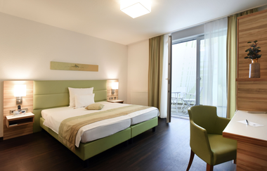 Helles modernes Hotelzimmer im Schloß-Hotel Ingelfingen mit Bett und Schreibtisch | © Touristikgemeinschaft Hohenlohe | Schloß-Hotel Ingelfingen