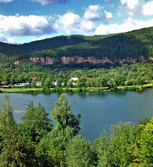 Blick von oben auf den Badesee in Freudenberg. Im Vorder- und Hintergrund ist Wald zu sehen. | © Liebliches Taubertal