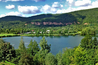 Blick von oben auf den Badesee in Freudenberg. Im Vorder- und Hintergrund ist Wald zu sehen. | © Liebliches Taubertal