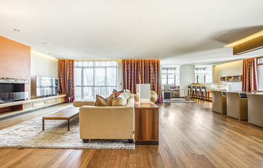 In der Präsidentensuite steht ein großes Sofa und eine große Tafel | © Touristikgemeinschaft Hohenlohe e. V. | Wald & Schlosshotel Friedrichsruhe