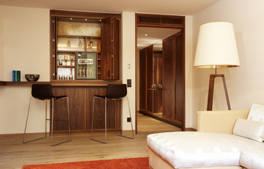 In diesem immer steht eine weiße Couch und es gibt eine kleine Bar | © Touristikgemeinschaft Hohenlohe e. V . | Wald & Schlosshotel Friedrichsruhe