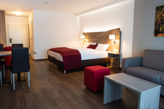 Hotelzimmer mit Doppelbett, Couch und kleiner Essecke | © Touristikgemeinschaft Hohenlohe e. V.