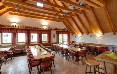 Die Besenwirtschaft ist rustikal mit Tischen und Stühlen eingerichtet. Die Decke hat helle Balken. | © Touristikgemeinschaft Hohenlohe e. V.