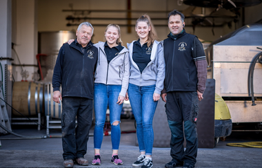 Vater, Sohn und zwei Töchter lächeln in die Kamera | © Touristikgemeinschaft Hohenlohe e. V. | Weingut Karl Busch