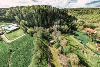 Aufnahme von der Luft aus, ein Wald mit einem Freibad sowie ein Wohnmobilsgtellplatz mit zwei Wohnmobilen. Buchen im Odenwald | © Touristikgemeinschaft Odenwald e.V.