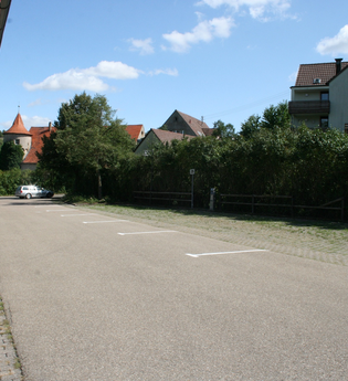 Blick auf den Wohnmobilstellplatz der Stadt Niederstetten. Im Hintergrund ist die Stadt zu sehen. Die Fläche ist asphaltiert. | © Stadt Niederstetten