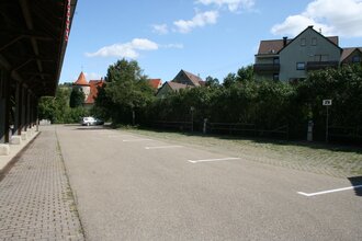 Blick auf den Wohnmobilstellplatz der Stadt Niederstetten. Im Hintergrund ist die Stadt zu sehen. Die Fläche ist asphaltiert. | © Stadt Niederstetten