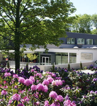 Blick auf Gebäude, die Katzenbuckel-Therme, davor eine Blumenfeld mit rosa und lila farbenen Blumen. Waldbrunn im Odenwald. | © Gemeinde Waldbrunn