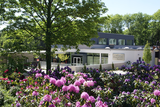 Blick auf Gebäude, die Katzenbuckel-Therme, davor eine Blumenfeld mit rosa und lila farbenen Blumen. Waldbrunn im Odenwald. | © Gemeinde Waldbrunn
