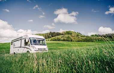 Ein weißes Wohnmobil inmitten von grünen Wiesen. Im Hintergrund ein bewaldter Hügel. Odenwald. | © Touristikgemeinschaft Odenwald e.V.