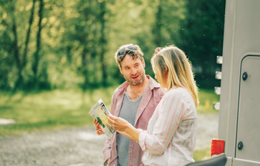 Ein Mann und eine Frau die in eine Karte schauen. Im Hintergrund ist Wald. Odenwald. | © Touristikgemeinschaft Odenwald e.V.