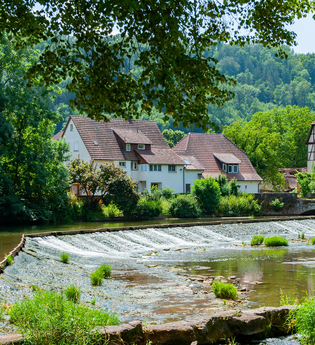 Vom Platz hat man einen schönen Blick auf das Kocherwehr und Fachwerkhäuser | © Touristikgemeinschaft Hohenlohe e. V. | Stadt Forchtenberg