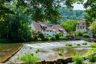 Vom Platz hat man einen schönen Blick auf das Kocherwehr und Fachwerkhäuser | © Touristikgemeinschaft Hohenlohe e. V. | Stadt Forchtenberg
