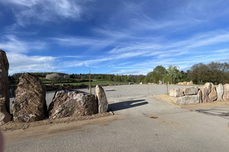 Einfahrt zu einem Wohnbmobilstellplatz. Die Begrenzung ist aus großen Findlingsteinen. Im Hintergrund sind Bäume. Limbach im Odenwald. | © Wohnmobilstellplatz Schuler