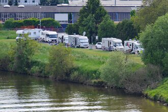 Ein Fluß an dessen Ufer ein Wohnmobilstellplatz ist. Es stehen mehrere Stellplätze in Reihe auf einer Wiese. Obrigheim im Odenwald. | © Gemeinde Obrigheim