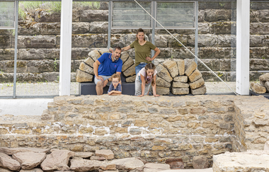 Eine Familie mit zwei Kindern ist in einem römischen Museum mit Ausgrabungen. Vor Ihnen sind Reste einer Ausgrabungsstätte. Osterburken im Odenwald | © Touristikgemeinschaft Odenwald e.V.